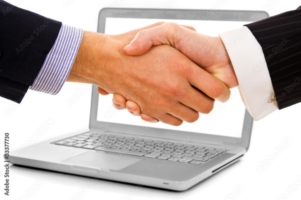 Businessmen shake hands from laptop computer Businessmen shake hands from laptop computer