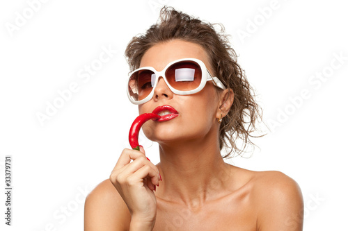 Closeup portrait of female in sunglasses holding chili pepper photo