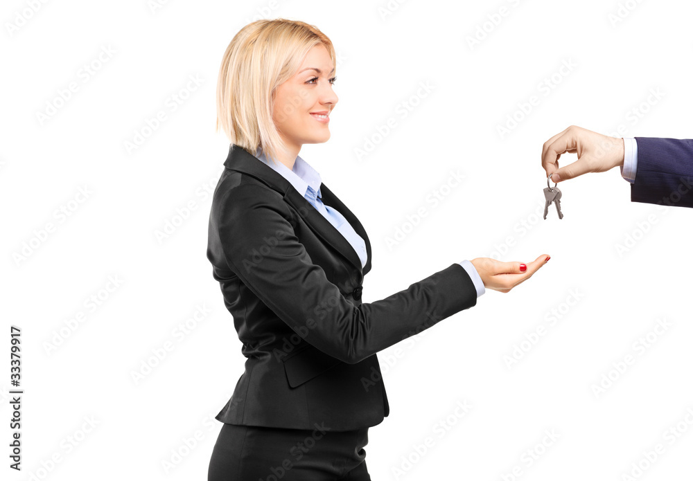 A blond businesswoman taking keys from a businessman A blond businesswoman taking keys from a businessman