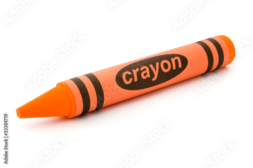 Single orange crayon isolated on white photo