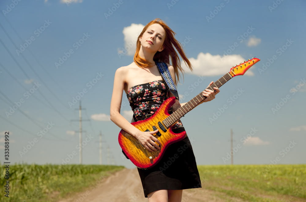 Rock girl with guitar at countryside. Rock girl with guitar at countryside.