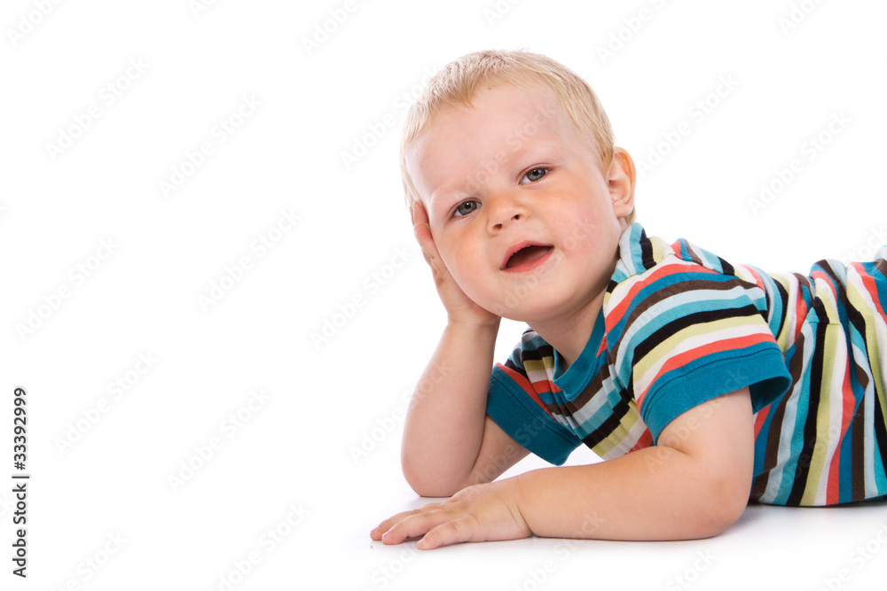 Portrait of a happy 2 year boy lying on a floor. Isolated over w Portrait of a happy 2 year boy lying on a floor. Isolated over w