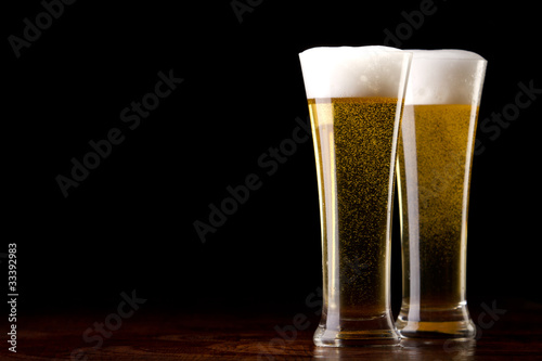 Beer into glass on a black and wooden table