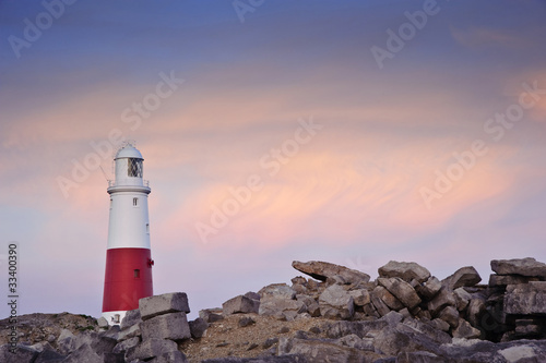 Victorian lighthouse on promontory of rocky cliffs during stunni