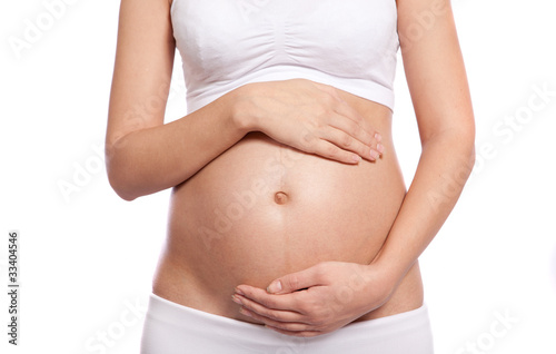 Image of pregnant woman touching her belly with hands © narcis1