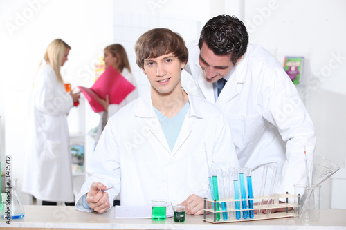 Teacher checking students work in laboratory
