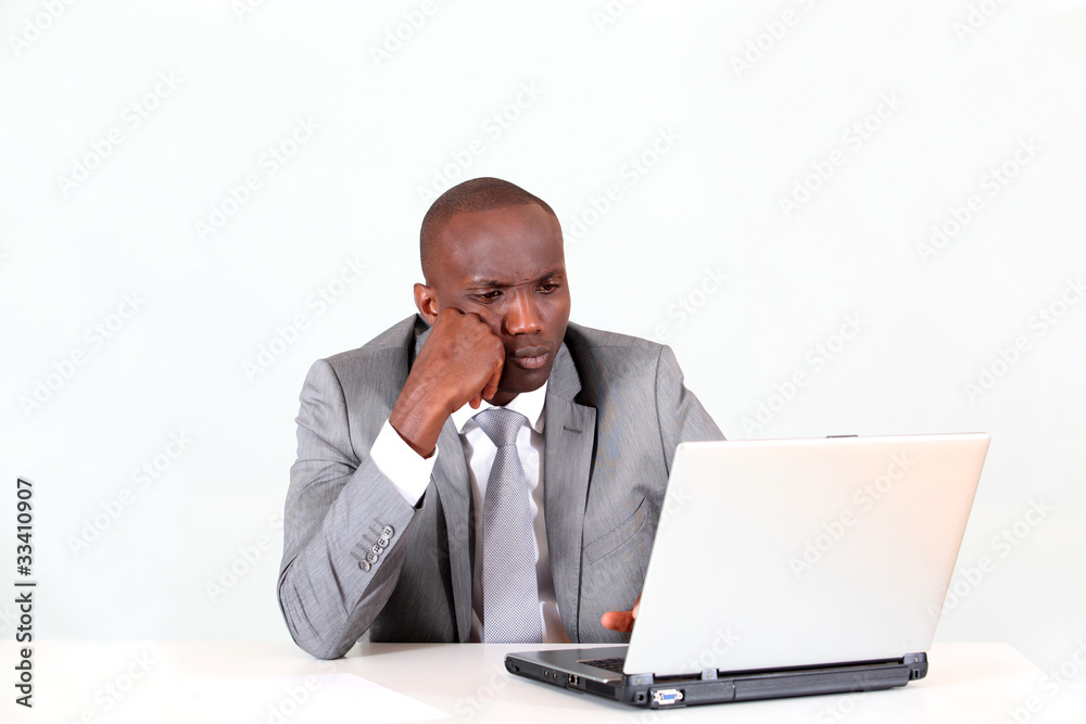 Businessman in office with thoughtful look Businessman in office with thoughtful look