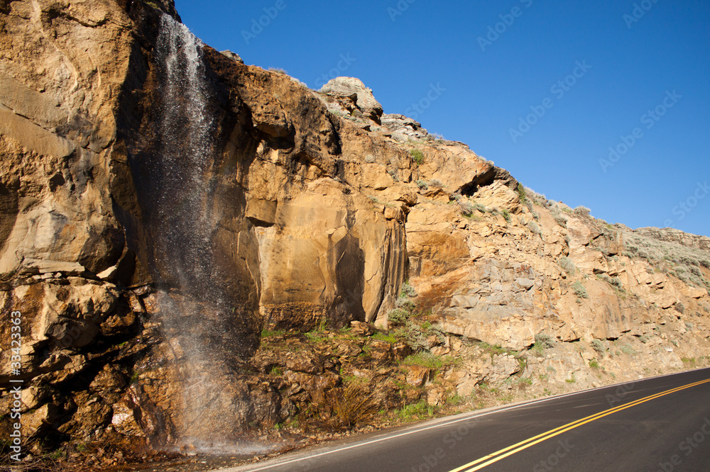 A nice image of a waterfall near a road.