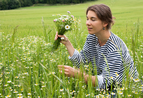 Jeune femme cueillant un bouquet de feurs photo