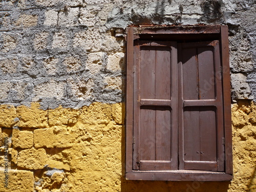 brown wood door in painted yellow stone wall doorway photo
