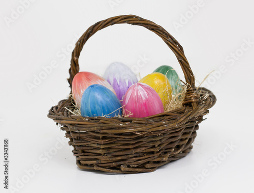 Basket with eastereggs on white background
