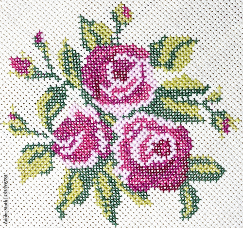 Old cross stitch embroidery of rose and leaves