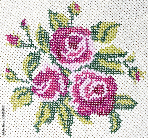 Old cross stitch embroidery of rose and leaves photo