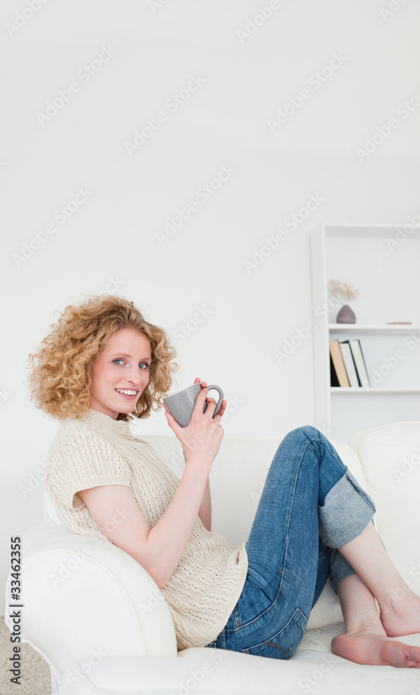 Beautiful blonde woman enjoying a cup of coffee while sitting on