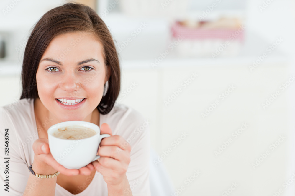 Smiling dark-haired woman having a coffee Smiling dark-haired woman having a coffee