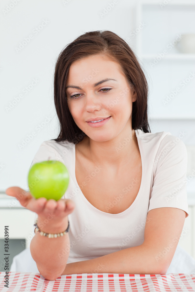 Smiling brunette showing an apple Smiling brunette showing an apple