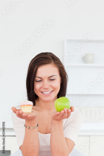 Portrait of a charming brunette with an apple and a piece of cak