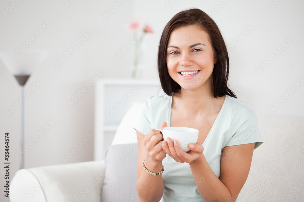 Close up of a dark-haired woman drinking tea Close up of a dark-haired woman drinking tea