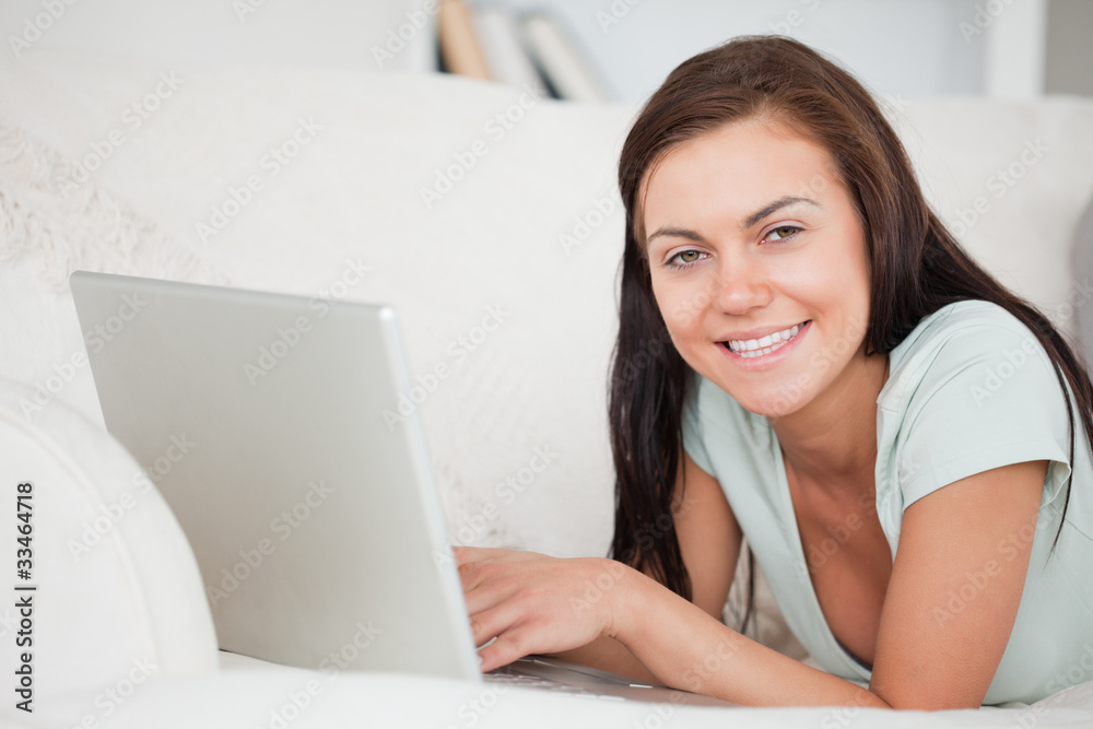 Close up of a brunette on a sofa using a laptop