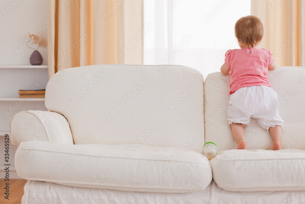 Blond baby standing on a sofa Blond baby standing on a sofa