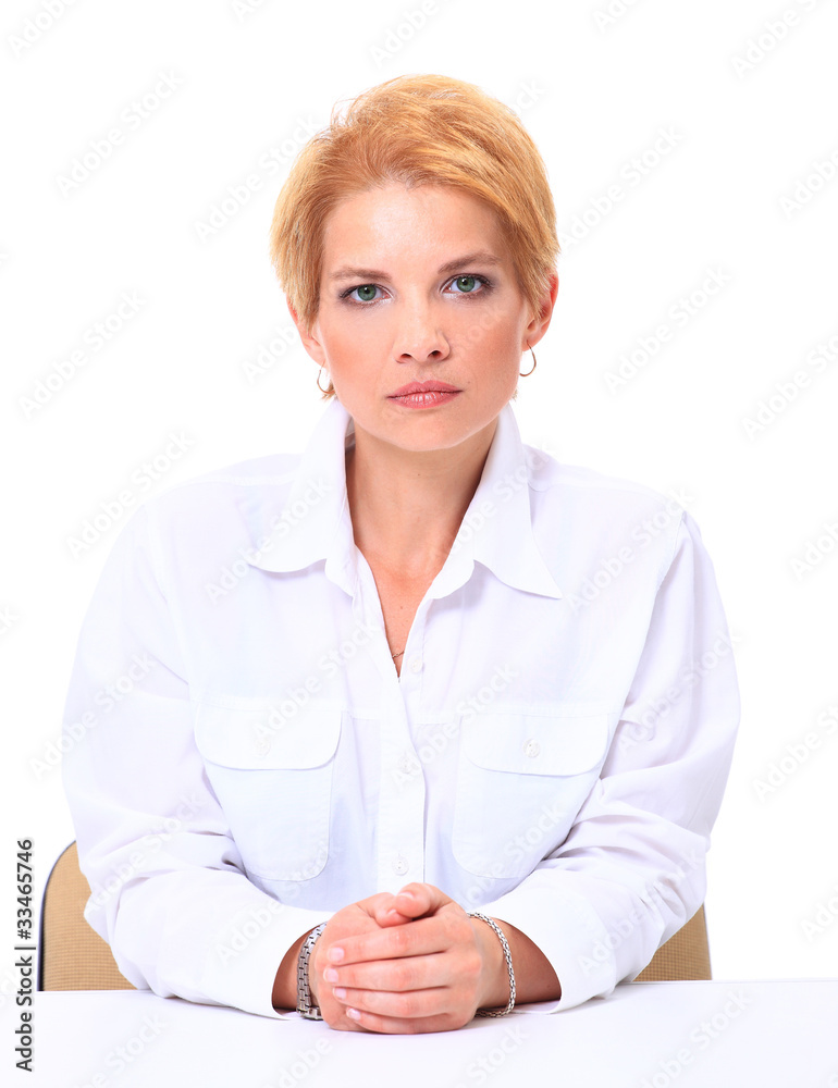 Blond smiling businesswoman sitting at her desk isolated Blond smiling businesswoman sitting at her desk isolated