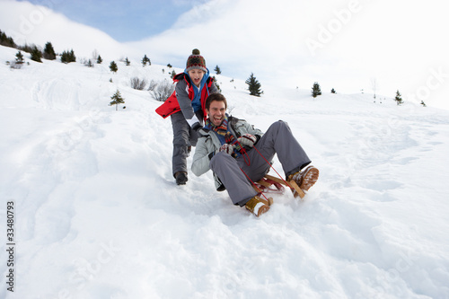 Young Father And Son Sledding