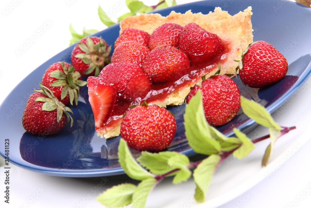 Piece of Strawberry Tart decorated with strawberries and mint