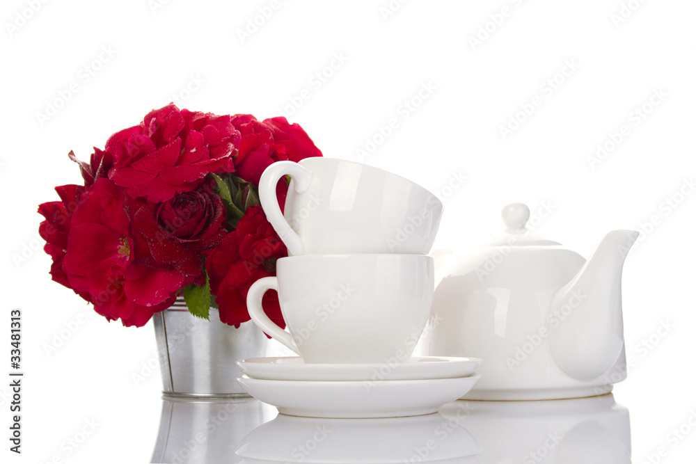 White crockery for tea and a bouquet of roses White crockery for tea and a bouquet of roses