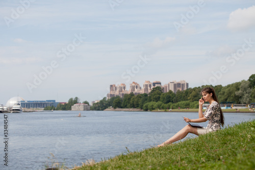 Young woman with laptop and mobile phone in the park. © Dmitriy Melnikov