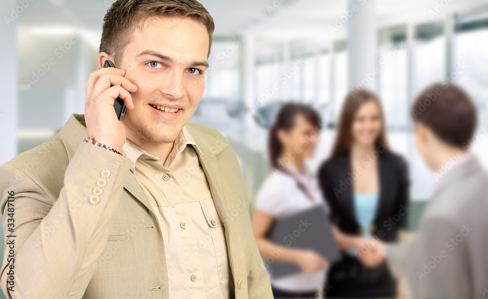 Young smiling businessman calling on phone at office Young smiling businessman calling on phone at office