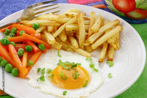 Fried egg , french fries and vegetables