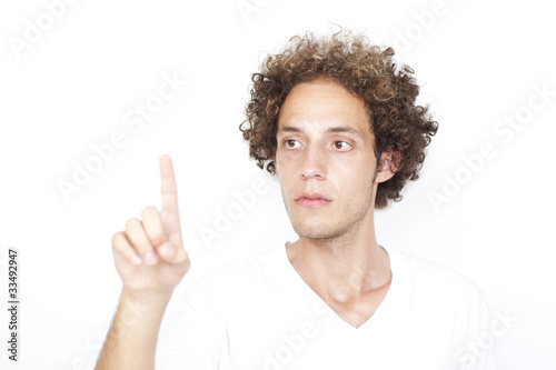 Junger Mann mit Locken drückt auf virtuellen Schirm