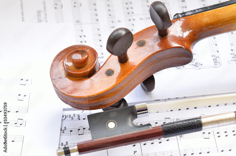 Naklejka premium Violin scroll with bow and music