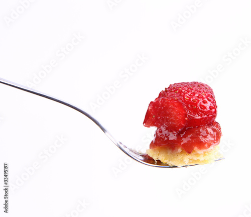 Piece of Strawberry Tart on a fork on a white background