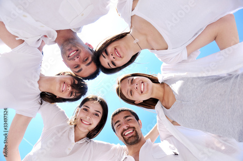 Group of happy young people in circle at beach