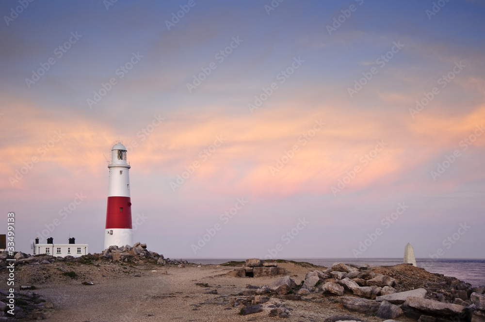 Victorian lighthouse on promontory of rocky cliffs during stunni