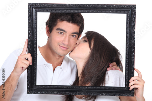 Fotografie Young couple kissing in a frame