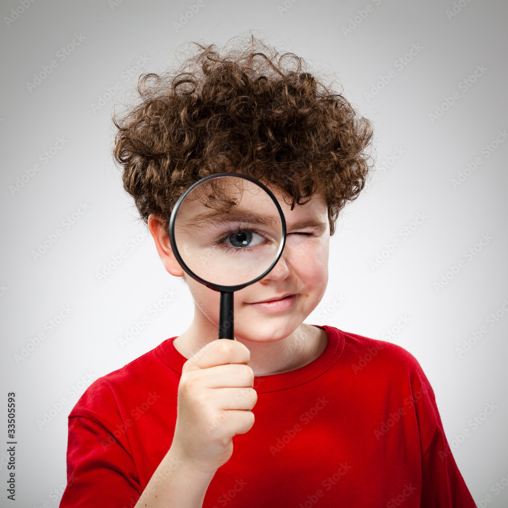 Boy looking through magnifying glass Boy looking through magnifying glass