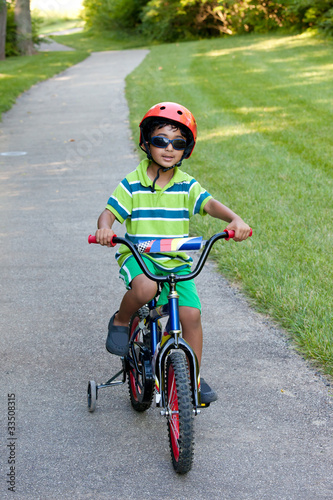 Fototapeta Naklejka Na Ścianę i Meble -  Child Riding His Bike on a Biking Trail in Summer