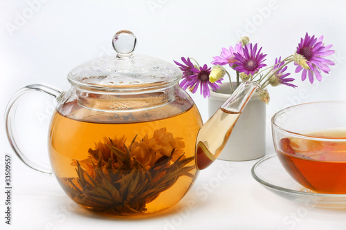 teapot, a cup of tea and a vase of flowers
