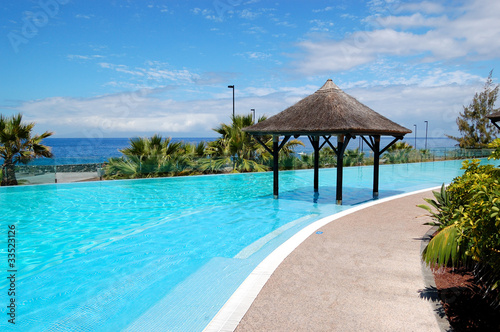 Swimming pool with Bali type hut and beach of luxury hotel  Tene