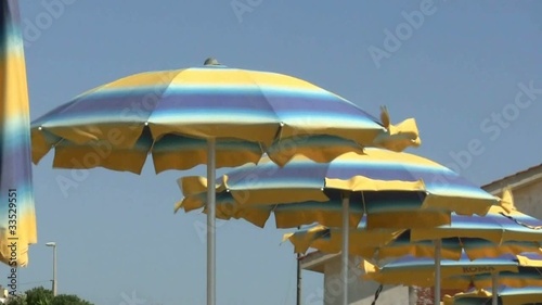 Ombrelloni sulla spiaggia smossi dal vento photo