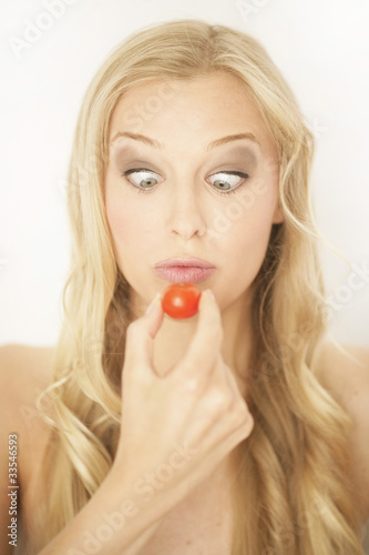 Blonde Frau mit Tomate