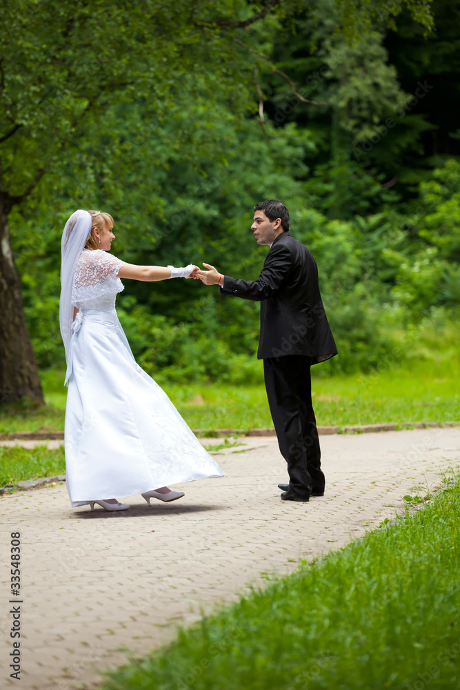 dancing wedding couple at a park on a sunny day dancing wedding couple at a park on a sunny day