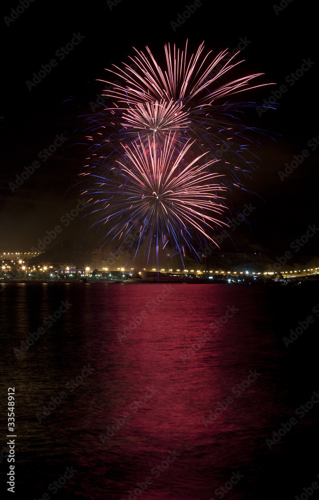 Fuegos artificiales con reflejo en el agua