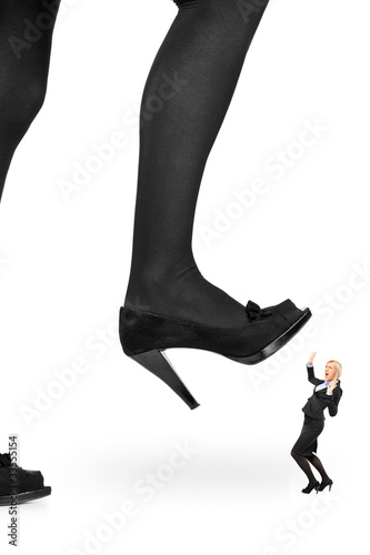 Big woman shoe stepping on a businesswoman