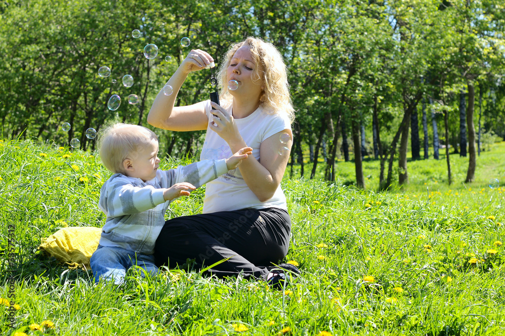 mother and child playing on green field mother and child playing on green field