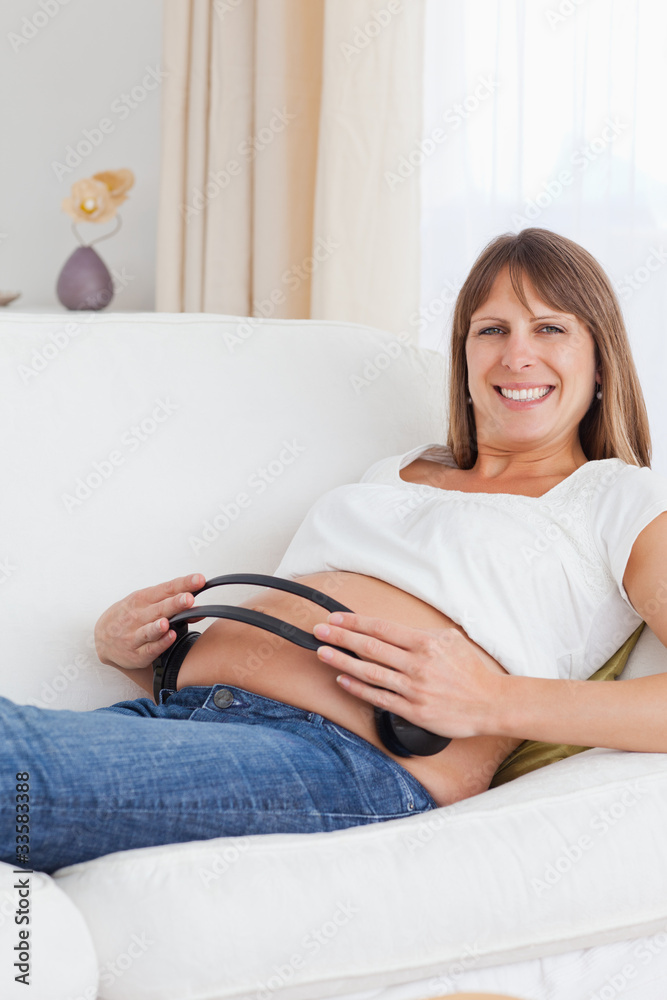Portrait of a pregnant woman with headphones on her belly Portrait of a pregnant woman with headphones on her belly