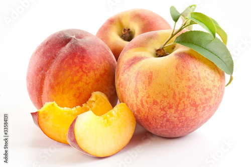 Ripe peach fruit with leaves and slices