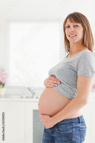 Free Download Beautiful pregnant woman posing while caressing her belly - GFXLoad